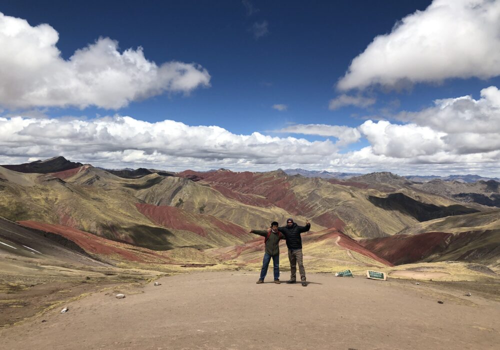 Travelers at the Second Lookout viewpoint overlooking Palcoyo's colored mountain ranges, an easier alternative to Rainbow Mountain